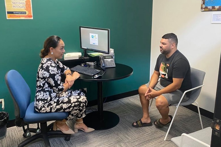 A woman financial counsellor speaks to Micheal Morris in an office at the YFS at Logan.