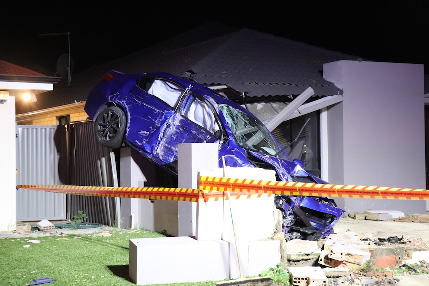 A car wedged on a fence in the front yard of a home in Piara Waters.
