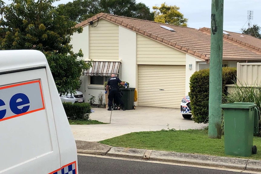 Police officer stands at bin outside Buderim home where groom was allegedly stabbed.