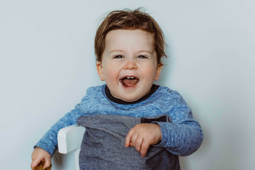 Alfie Chivers sitting on a chair and smiling at the camera