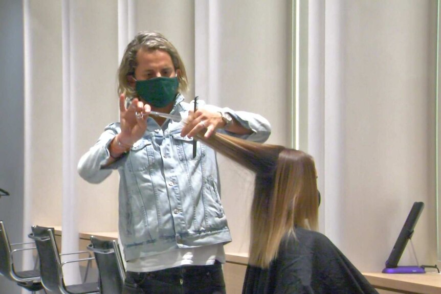 A photo of hairdresser Joey Scandizzo cutting the hair of a client