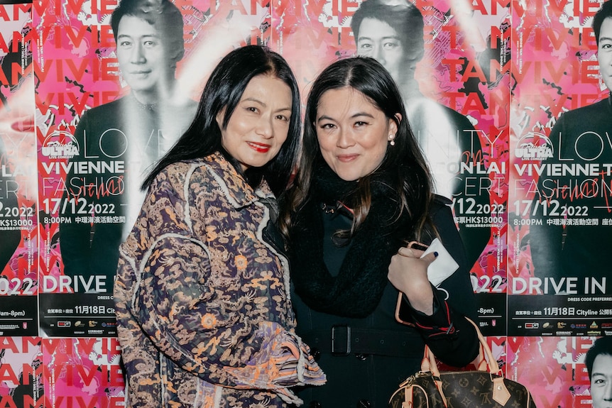 Faye Bradley (right) stands next to Vivienne Tam at the premiere of a new movie. Faye holds a Louis Vuitton bag on her left arm