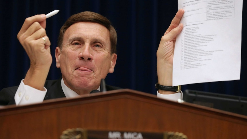 Republican Senator for Florida John Mica (R-FL) holds a fake hand-rolled cigarette and a list of marijuana offenses