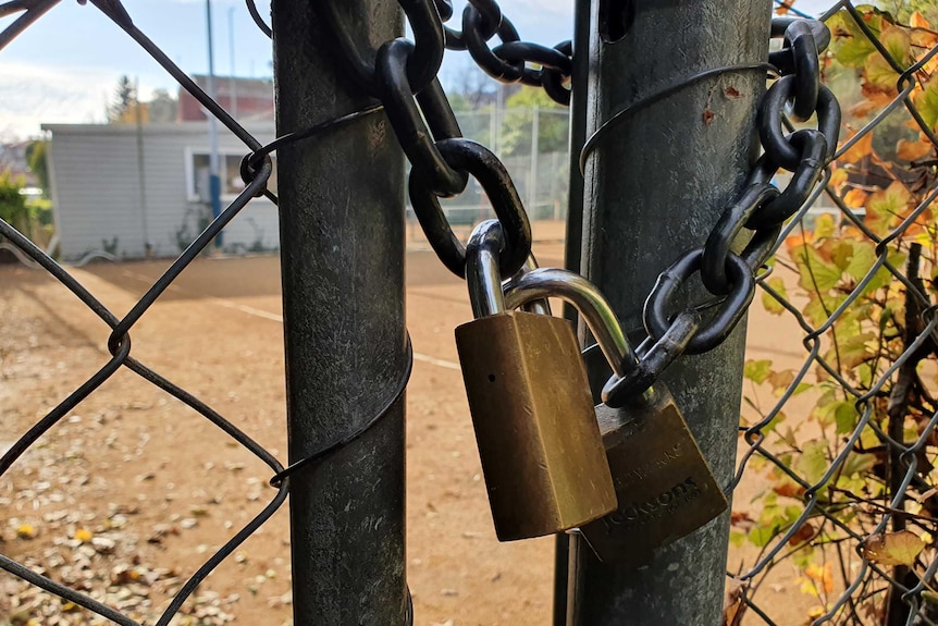 A lock on a tennis court gate.