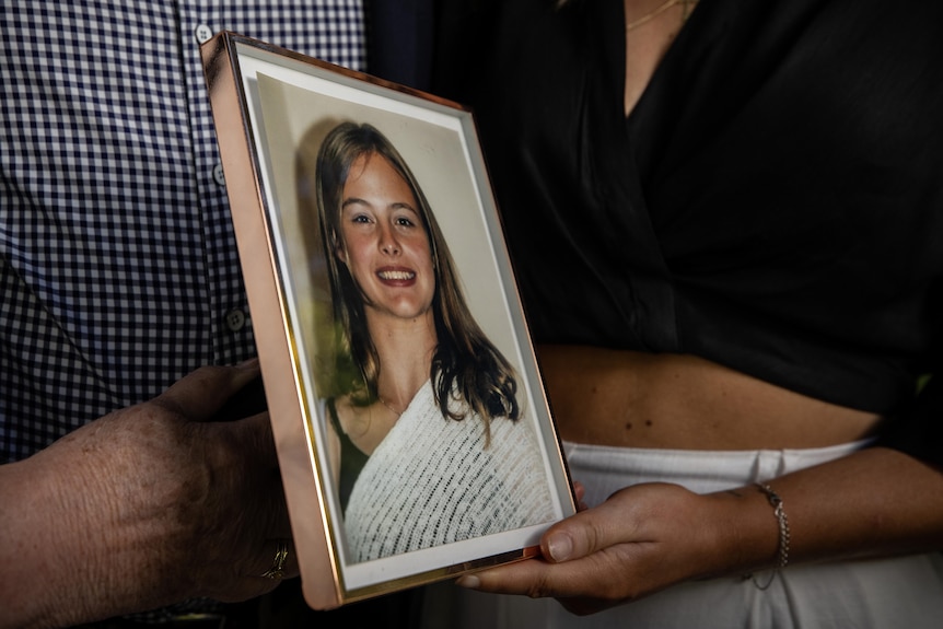 Framed photo of Zoe Duncan held by members of her family.