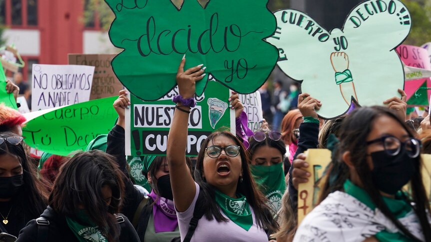 A woman in a rally holding a sign which reads Lo decido yo.