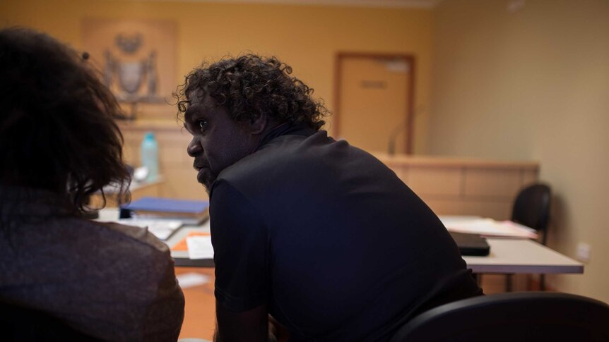 Aboriginal interpreter Clayton helps a man in court in Blackstone, WA.