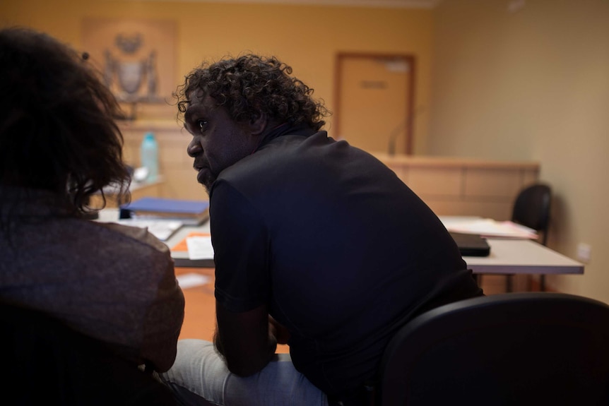 Aboriginal interpreter Clayton helps a man in court in Blackstone, WA.