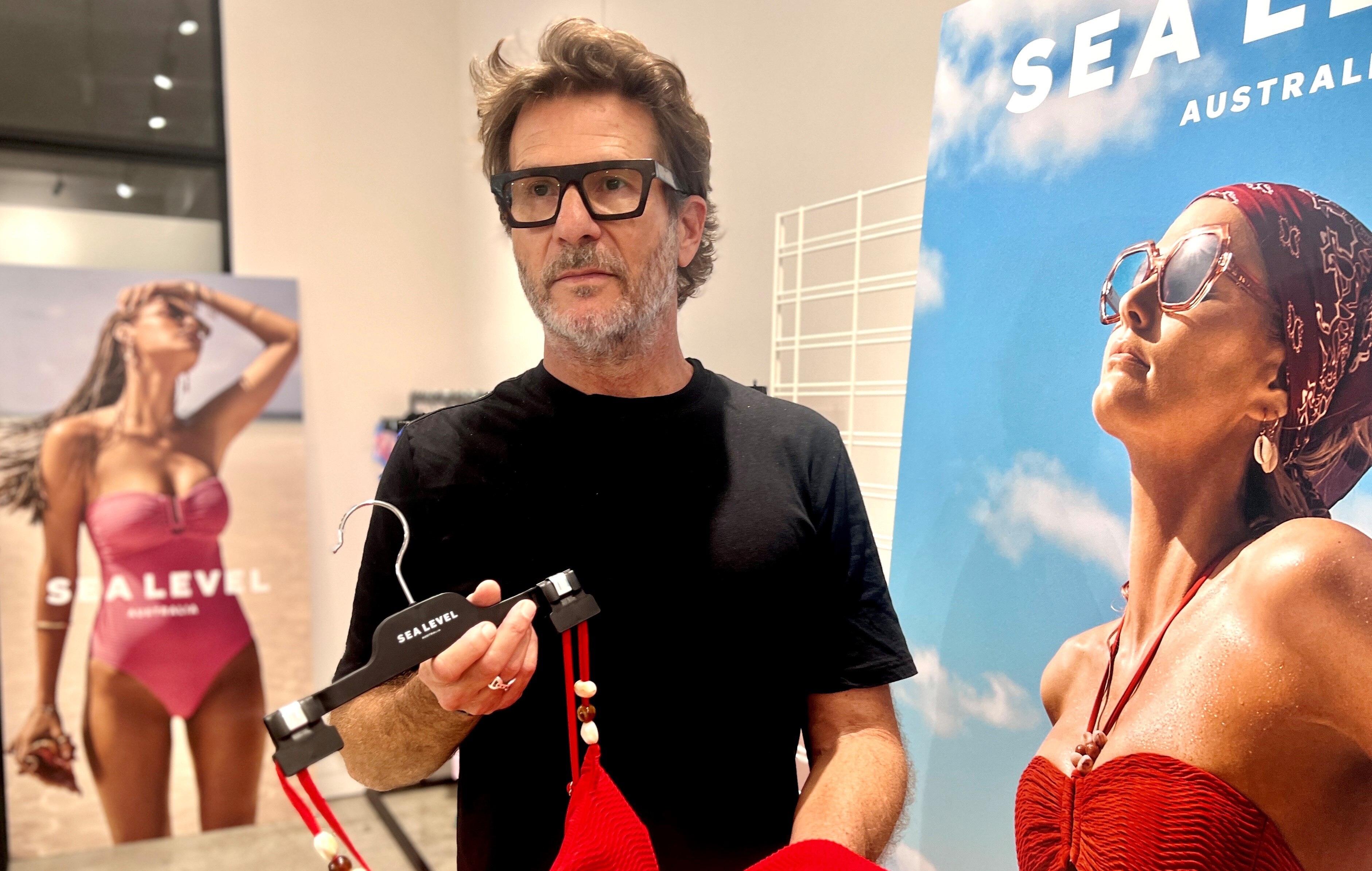 戴眼鏡的男子手持泳裝