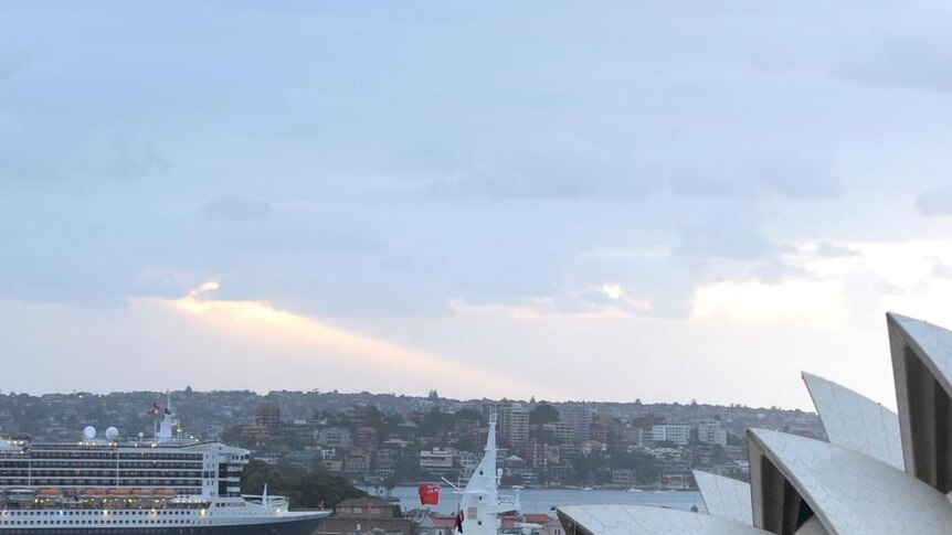 The Queen Elizabeth (foreground) and the Queen Mary 2 arrive in Sydney Harbour