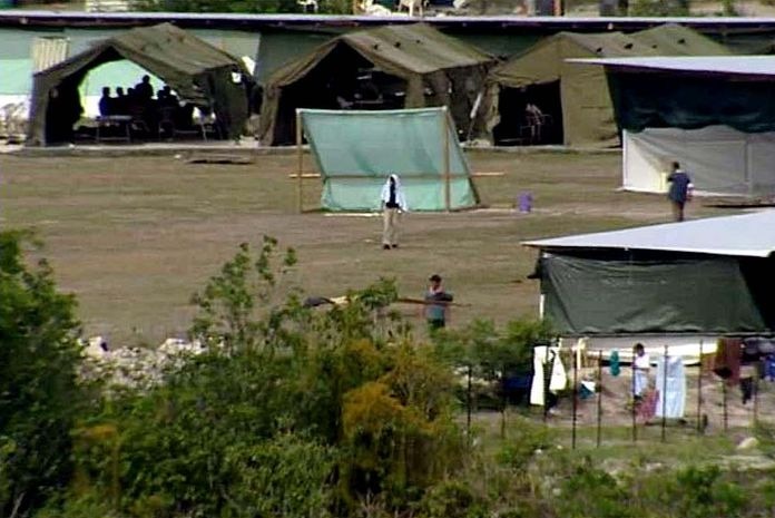 Refugees walk about the detention centre on the island of Nauru