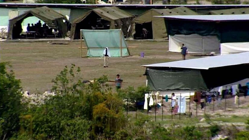 Refugees walk about the detention centre on the island of Nauru