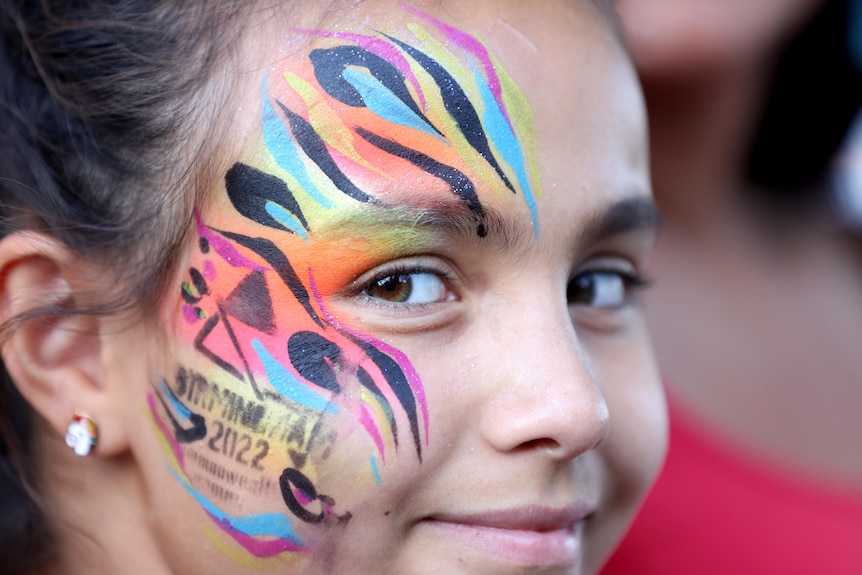 A child in Birmingham 2022 Commonwealth Games face paint before the closing ceremony.