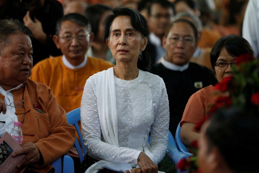 A woman has a serious look on her face sitting in a crowd