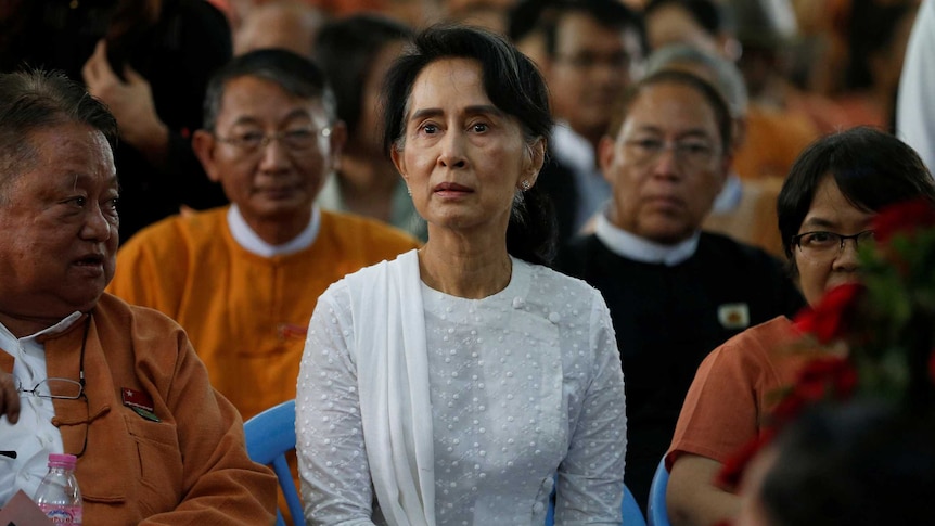 A woman has a serious look on her face sitting in a crowd