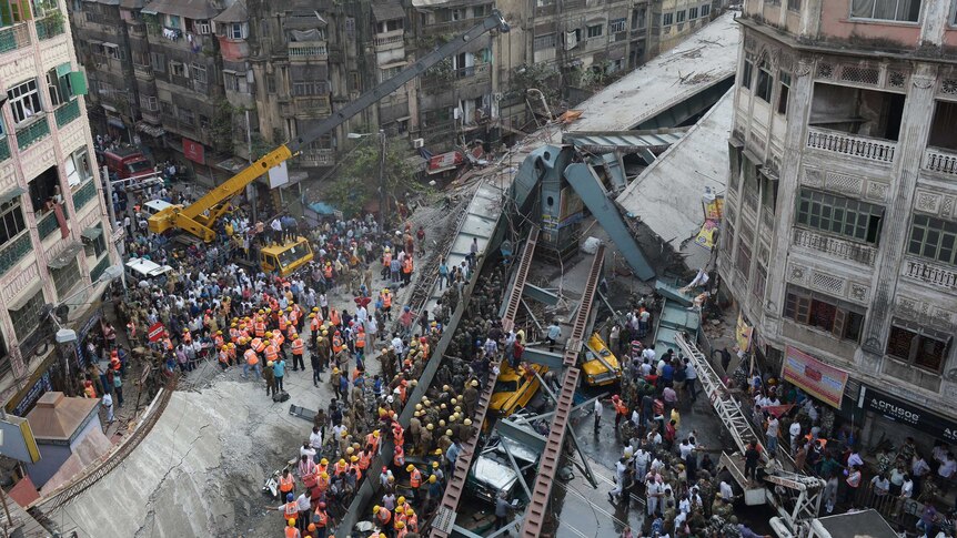 Aerial view of the Kolkata bridge overpass collapse, large crowds watch as emergency services free people from the rubble