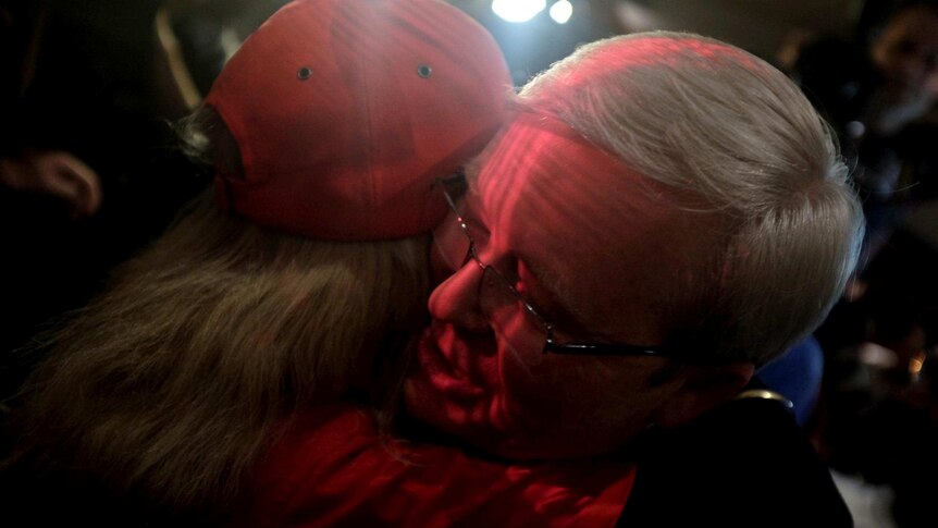 Kevin Rudd is hugged by a supporter after he concedes defeat in the federal election and steps down as ALP leader.