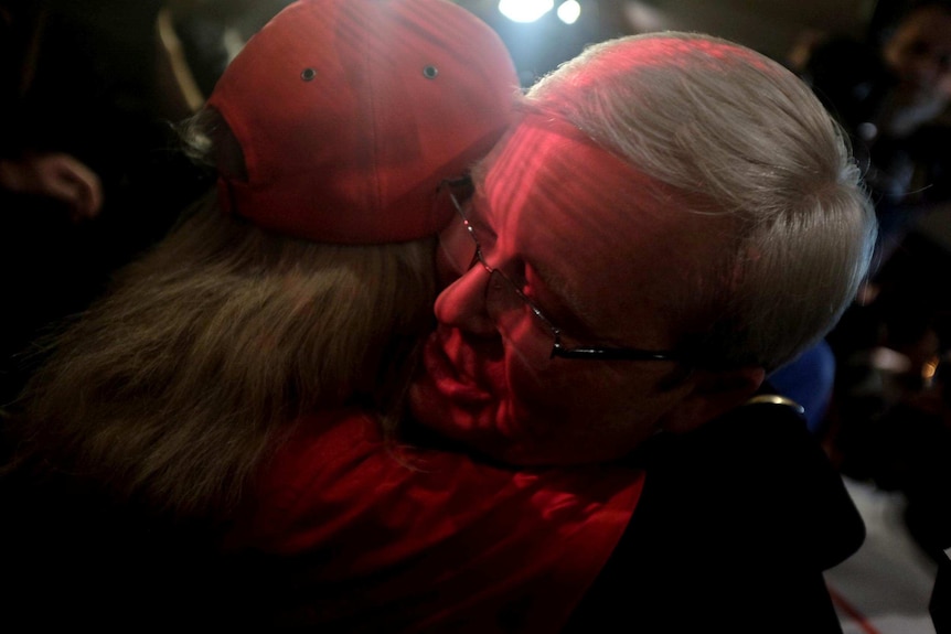 Kevin Rudd is hugged by a supporter after he concedes defeat in the federal election and steps down as ALP leader.