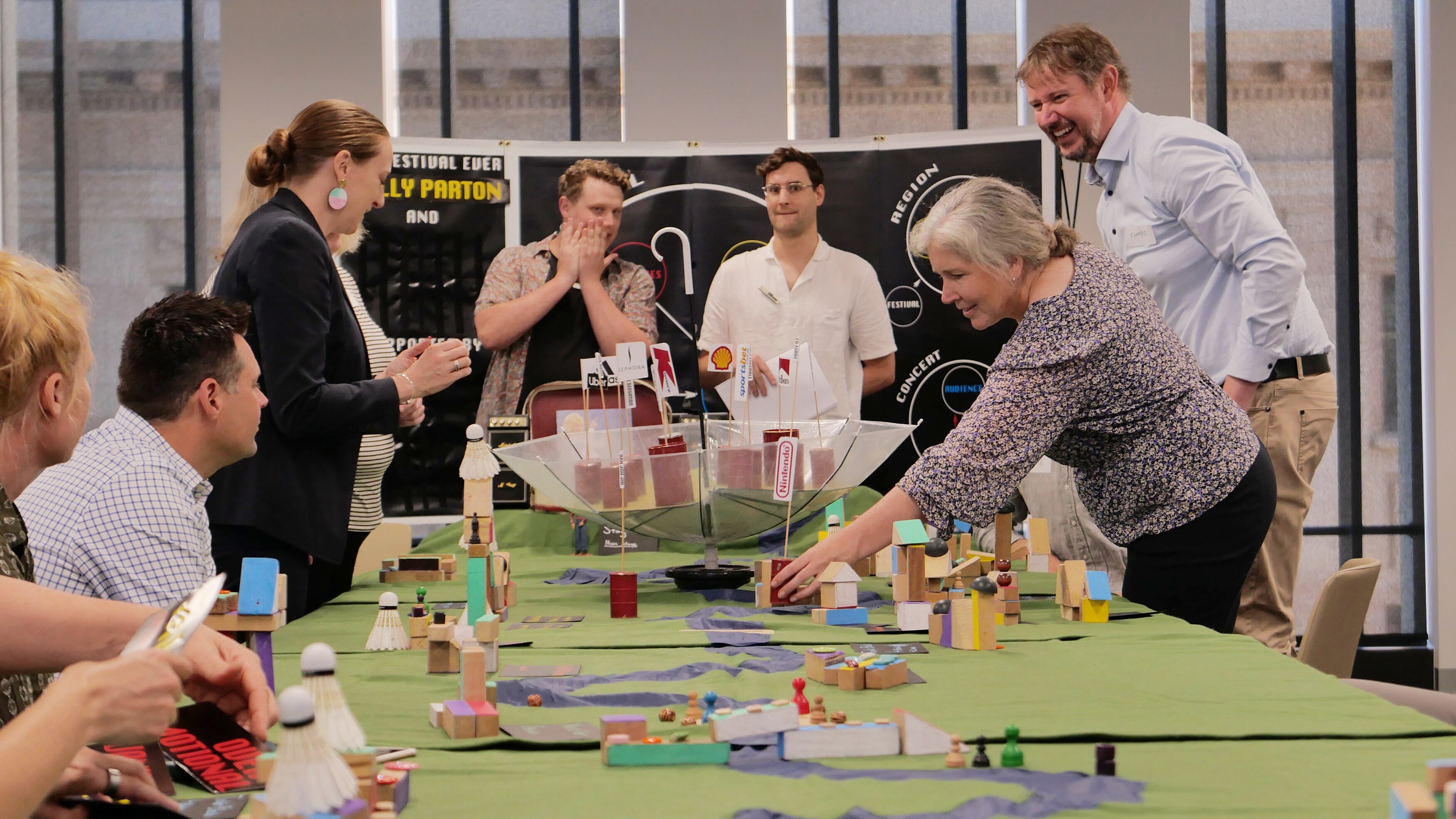 Men and women around a table with various objects on it.