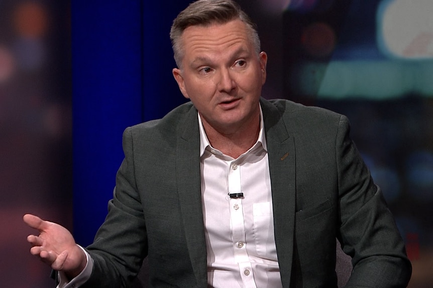 Chris Bowen wears a suit and gesticulates.