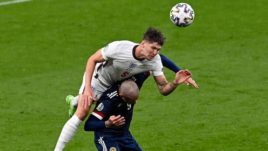 John Stones climbs over Lyndon Dykes