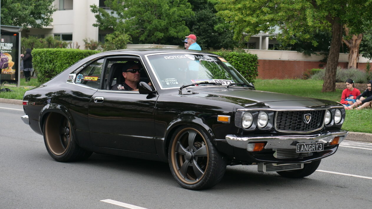 A man driving a black car in Canberra.