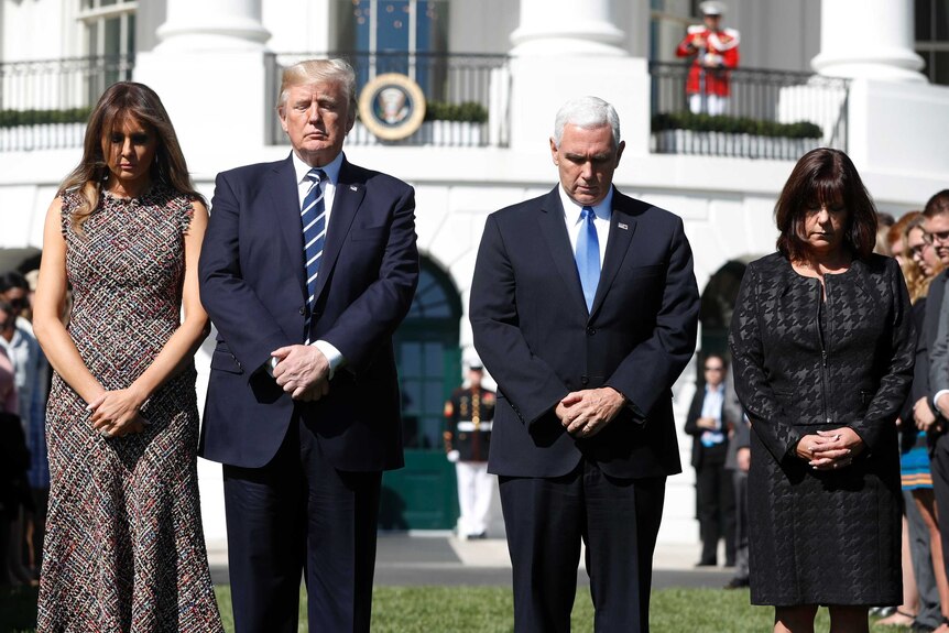 Melania and Donald Trump and Mike and Karen Pence observe a minute's silence in front of the White House.