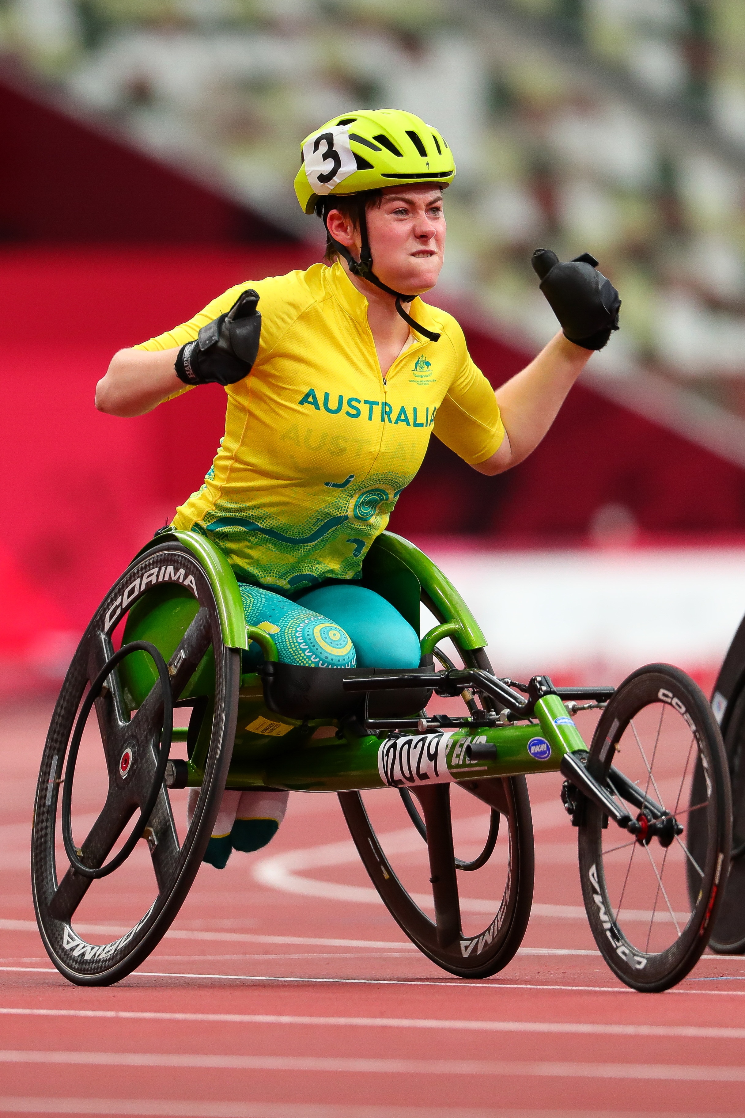Wheelchair racer Robyn Lambird pumps their fists after winning a bronze medal
