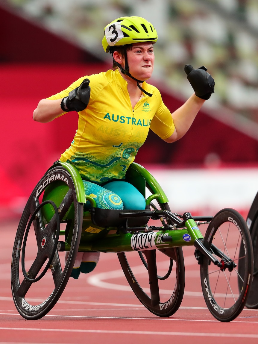 Wheelchair racer Robyn Lambird pumps their fists after winning a bronze medal