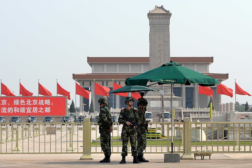 Armed Chinese police stand guard on Tiananmen Square.