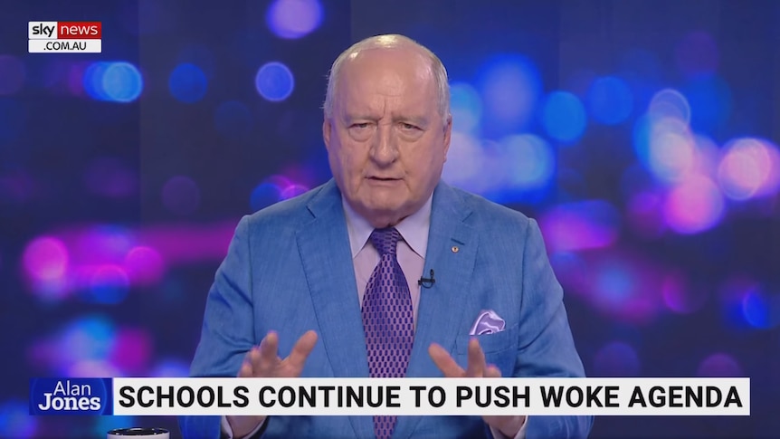 screenshot of Alan Jones wearing blue shirt and purple tie in a tv studio with Sky News graphics