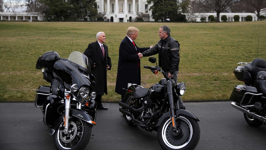 US President Donald Trump shakes hands with Matthew S Levatich, CEO of Harley Davidson.