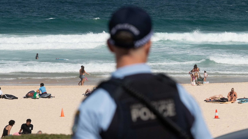 A police officer looks out at patrons on Bondi Beach.