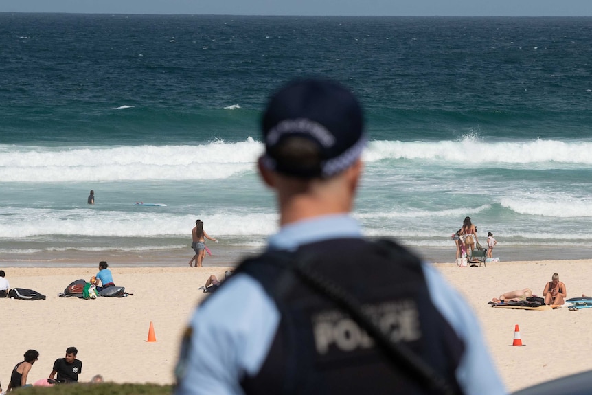 A police officer looks out at patrons on Bondi Beach.