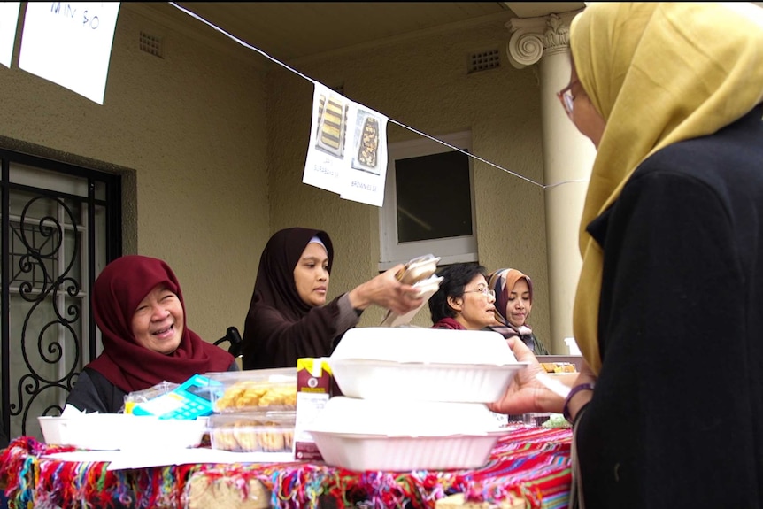 Couple of ladies handling food to buyers