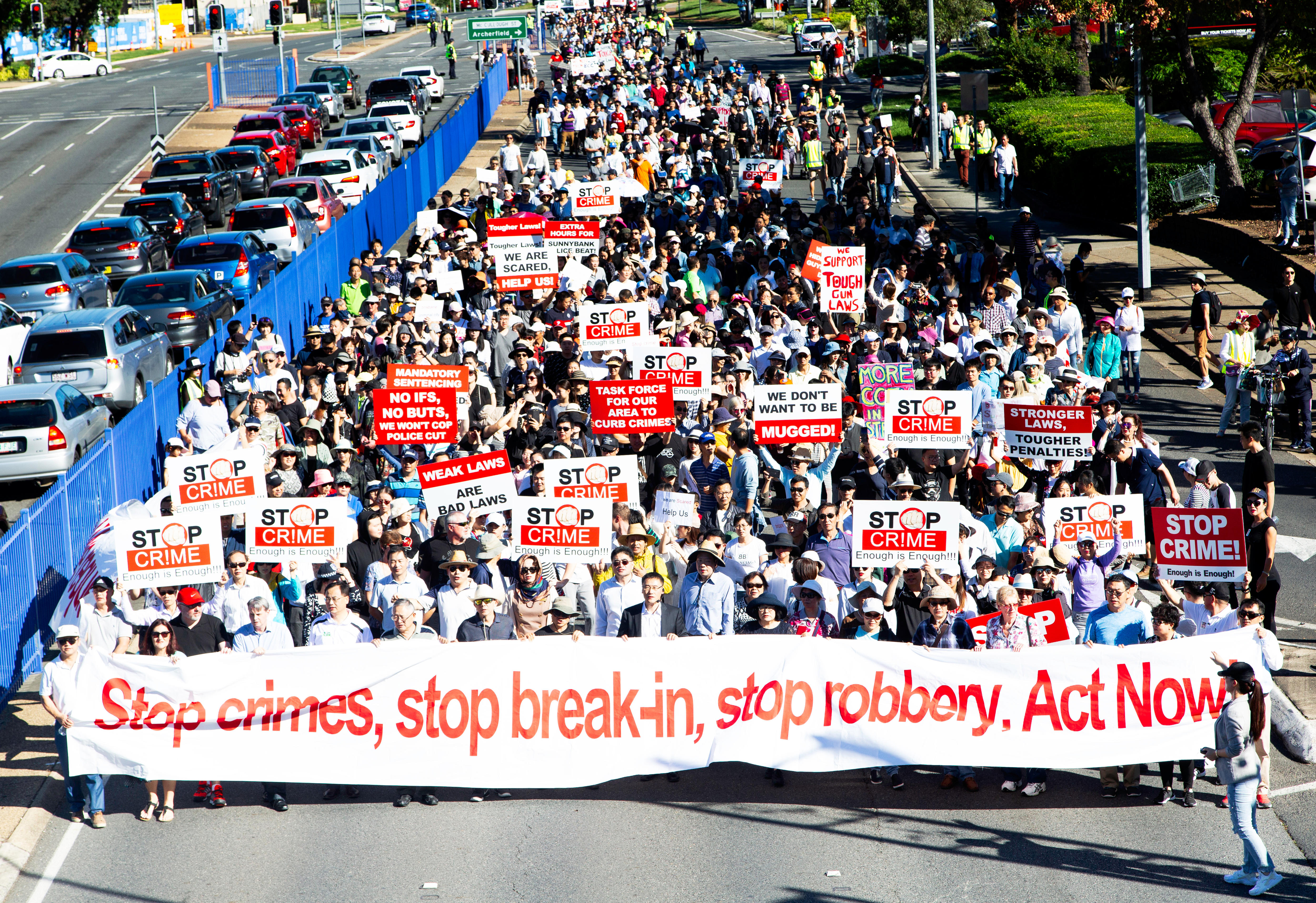 More than 1,000 people with signs that say "stop crime"
