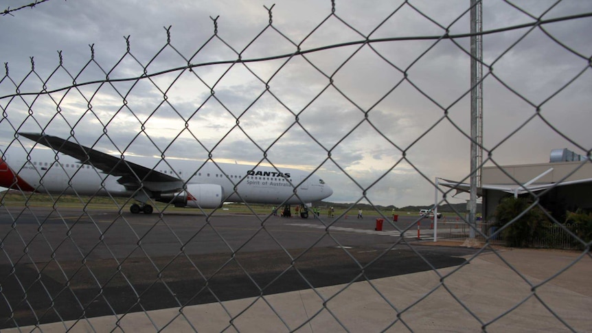 Qantas plane behind fence on airstrip