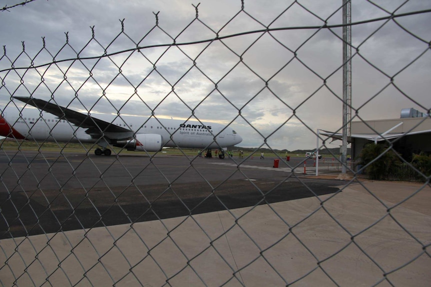 Qantas plane behind fence on airstrip