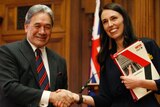 (Left) Winston Peters shakes hands with Jacinda Ardern after they sign a coalition agreement.