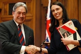 (Left) Winston Peters shakes hands with Jacinda Ardern after they sign a coalition agreement.