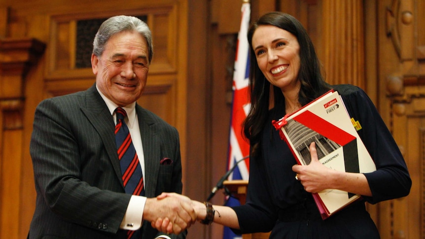 Winston Peters shakes hands with Jacinda Ardern after they sign a coalition agreement.