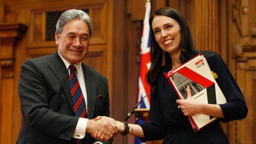 (Left) Winston Peters shakes hands with Jacinda Ardern after they sign a coalition agreement.