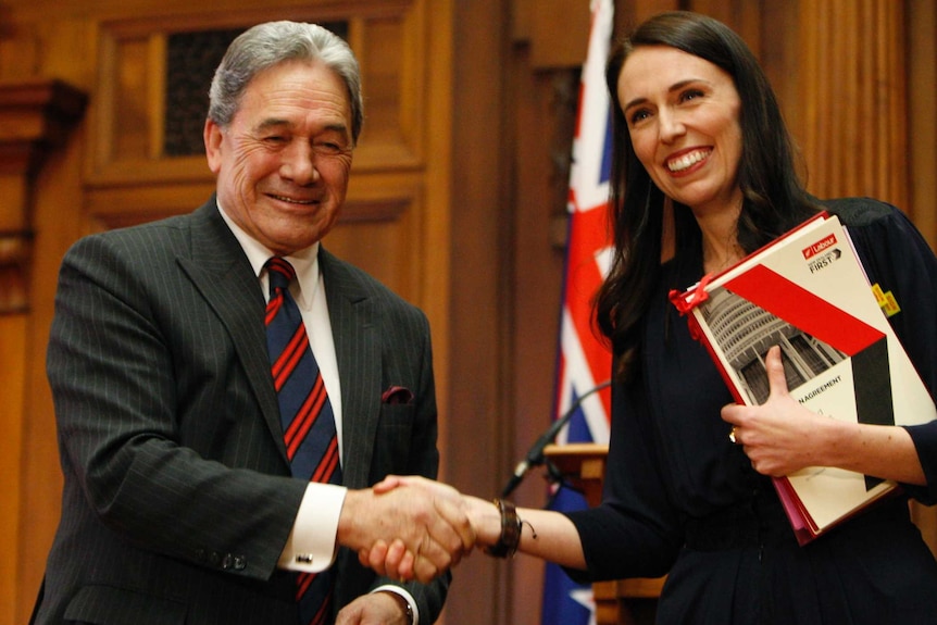 (Left) Winston Peters shakes hands with Jacinda Ardern after they sign a coalition agreement.