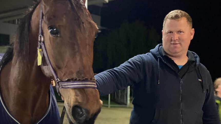 Ben Yole holds bridle of a horse.