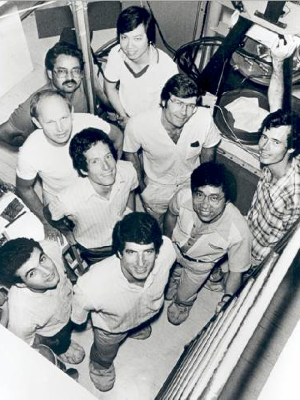 A black-and-white photo of mine smiling men in shirt sleeves