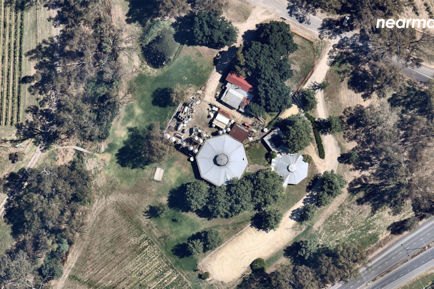 A home can be seen from the air, with paddocks and gardens around it