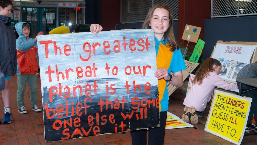 A girl hold a sign with climate change protest message