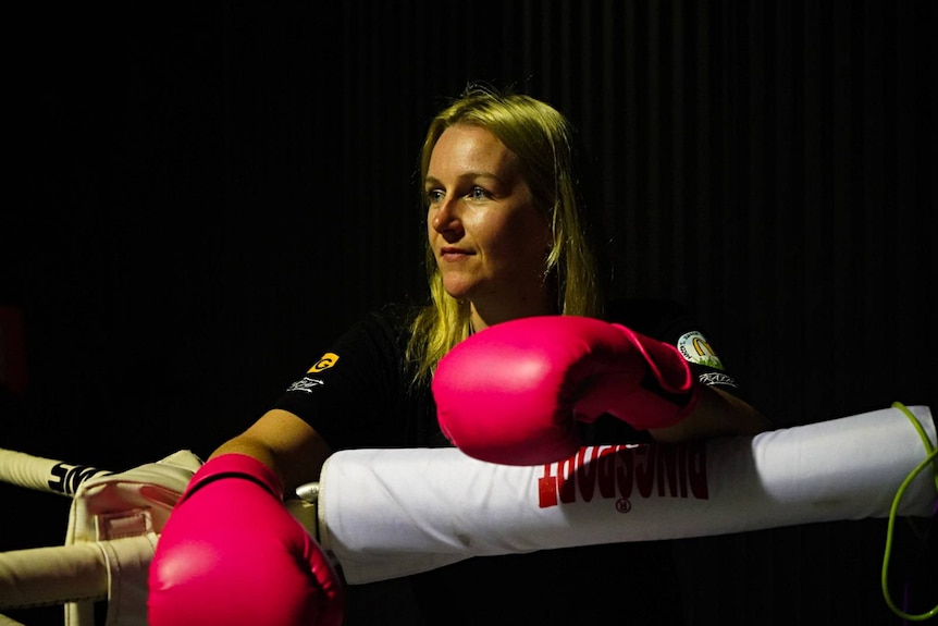 Woman over boxing ring in hot pink gloves 