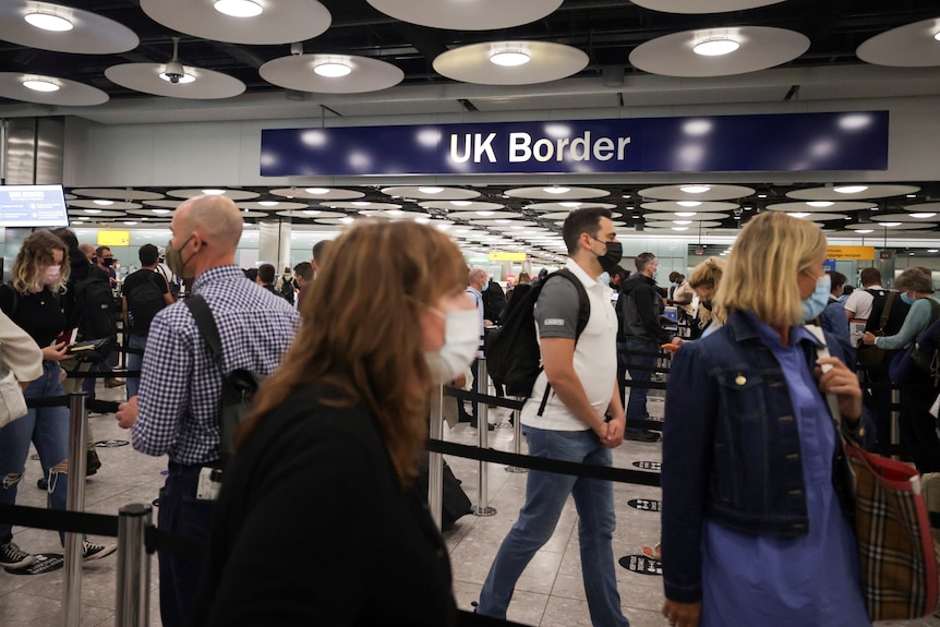 Arriving passengers queue at UK Border Control at Heathrow Airport