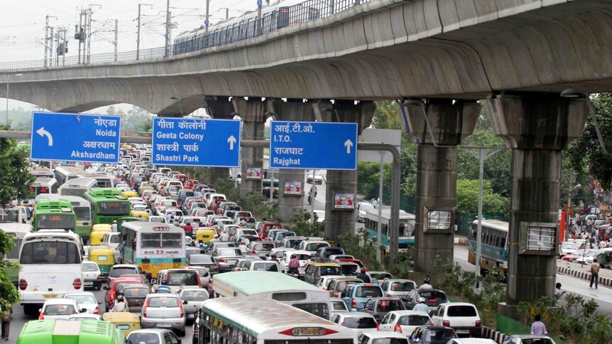 Buses, cars and motorcycles sit bumper to bumper in traffic on a busy road in the Indian capital.